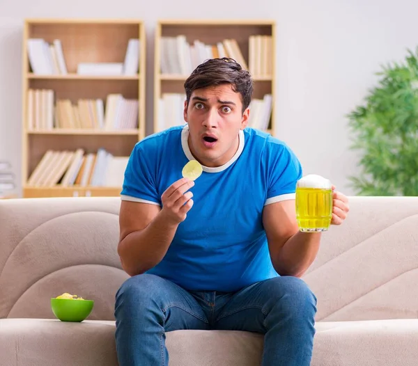 Hombre viendo fútbol en casa sentado en el sofá — Foto de Stock