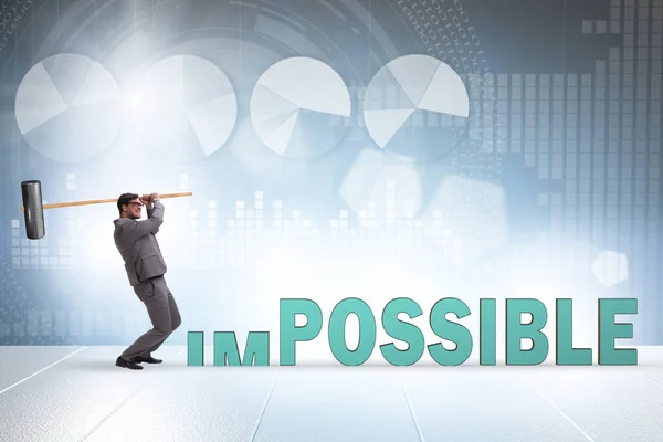 Бизнесмен бьет молотком по слову "невозможно" — стоковое фото