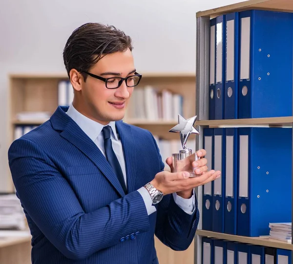 Young man standing next to the shelf with folders — Stock Photo, Image