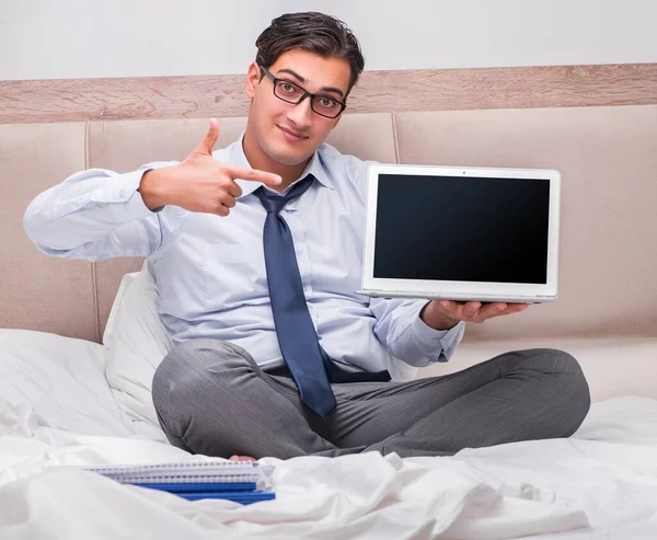Affärsman som arbetar i sängen hemma — Stockfoto