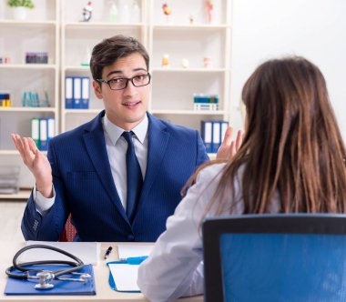 İş adamı doktorla sağlık sorunlarını tartışıyor