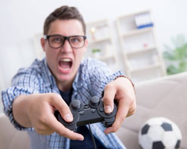 Genç adam evde bilgisayar oyunu oynuyor.