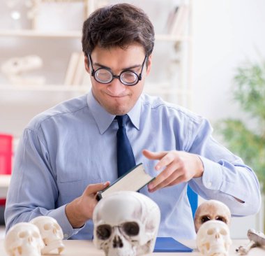 Komik çılgın profesör insan iskeletini inceliyor.