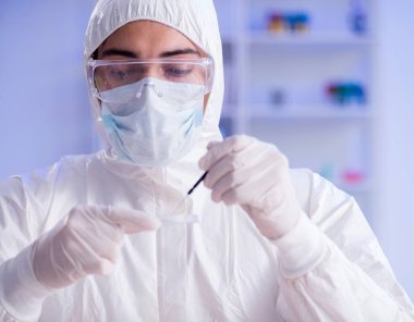 Laboratuvar asistanı hastanede kan örneklerini test ediyor.