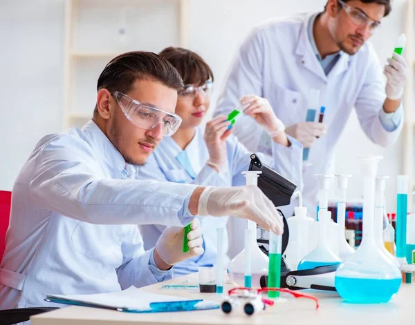 Equipe de químicos que trabalham no laboratório — Fotografia de Stock