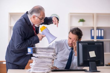 Eski patron ve genç erkek çalışan ofiste.