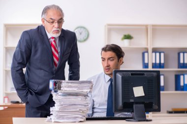 Eski patron ve genç erkek çalışan ofiste.