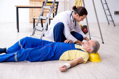 İlk yardım konseptinde genç erkek doktor ve yaşlı müteahhit.