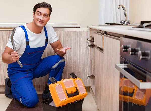 Jonge reparateur werkt in de keuken — Stockfoto