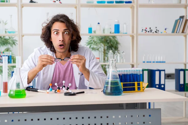 Grappige mannelijke chemicus die in het lab werkt — Stockfoto