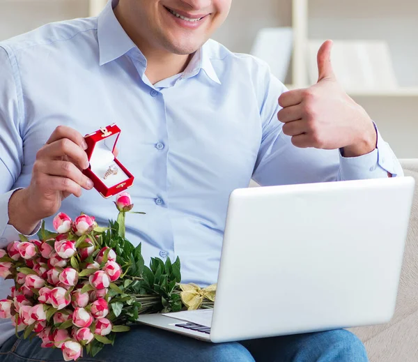 Jovem fazendo proposta de casamento através de laptop na internet — Fotografia de Stock
