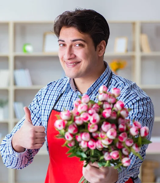 Asistente de floristería ofreciendo un ramo de flores — Foto de Stock