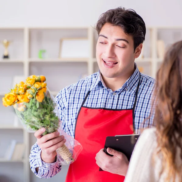 Asistente de floristería vendiendo flores a cliente femenino — Foto de Stock