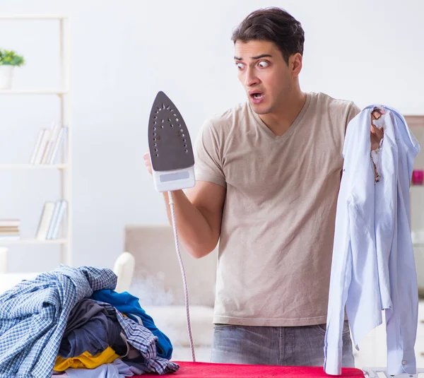 Marido desatento queimando roupas enquanto passa a ferro — Fotografia de Stock