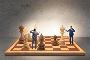 Strateji kavramında büyük satranç tahtasında iş adamı