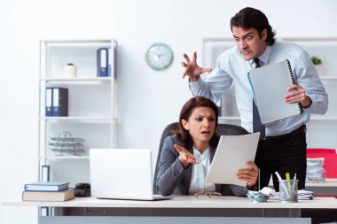 Yaşlı kadın patron ve genç erkek çalışan ofiste.