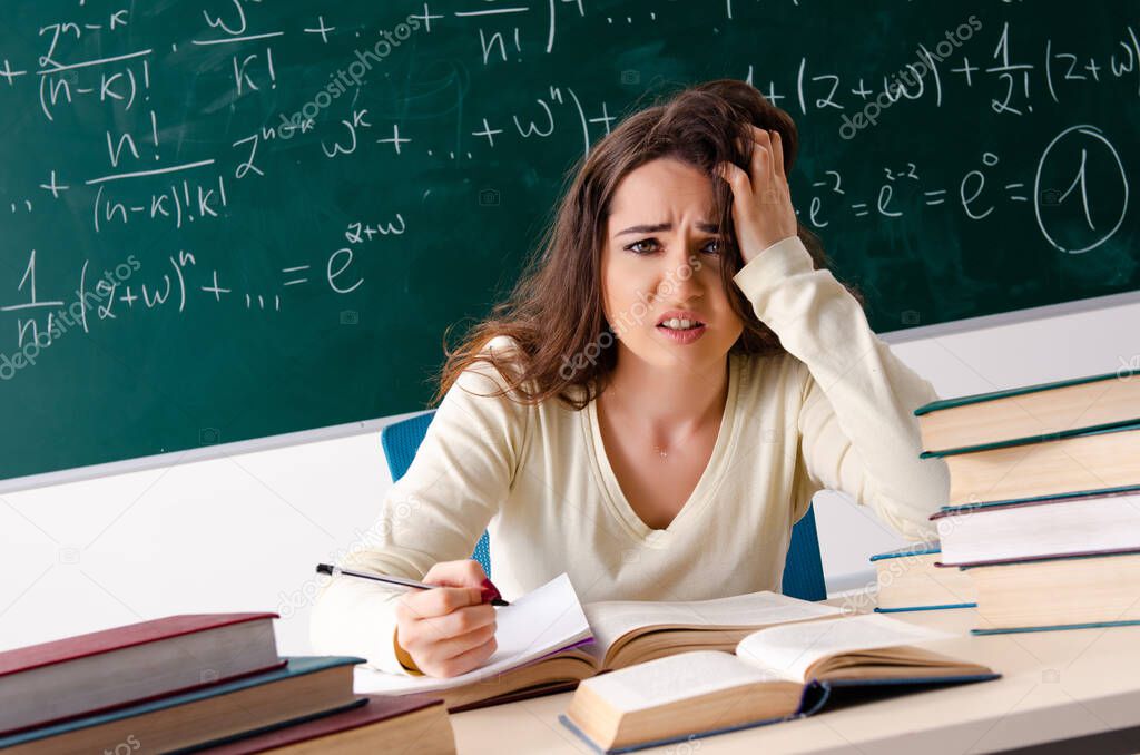 Young female math teacher in front of chalkboard