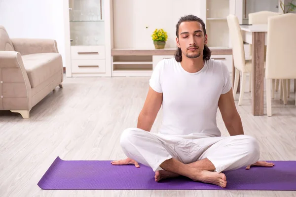 Jovem fazendo exercícios físicos em casa — Fotografia de Stock