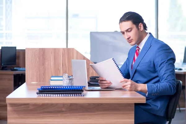 Молодой привлекательный бизнесмен сидит в офисе — стоковое фото