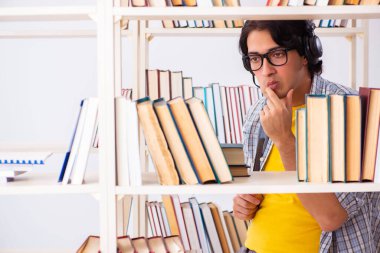 Erkek öğrenci kütüphanede sınava hazırlanıyor