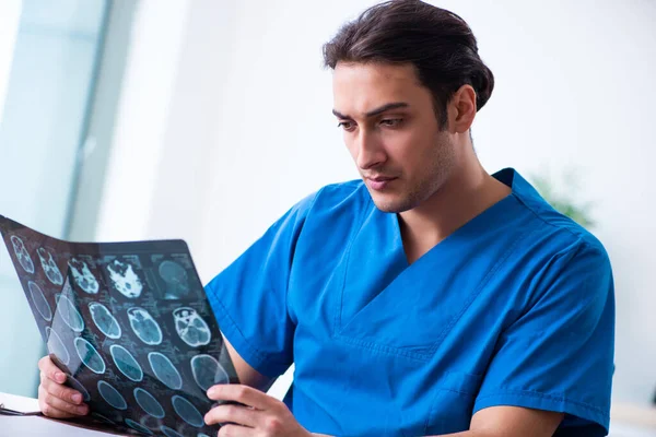 Médico jovem olhando para imagens de raios-x — Fotografia de Stock