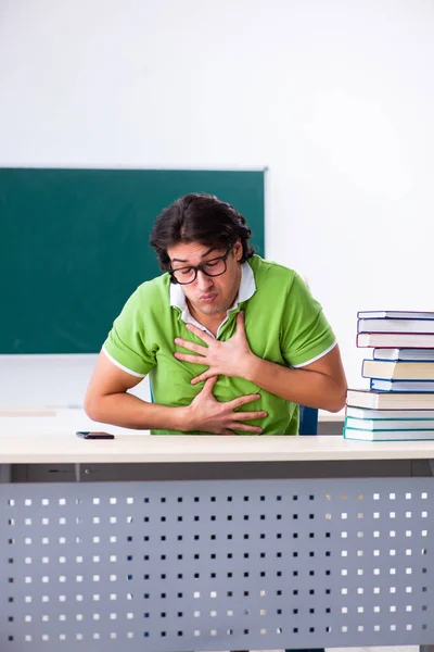 Young male student in front of green board — Stock Photo, Image