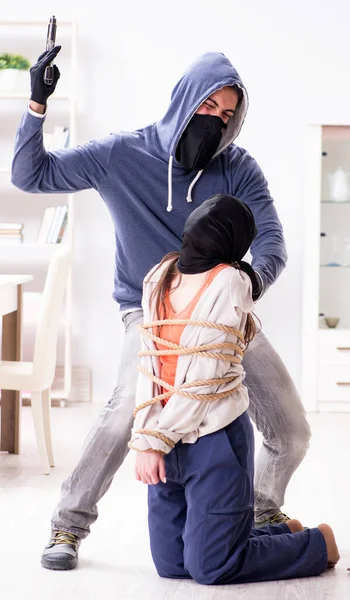 Озброєний чоловік нападає на молоду жінку вдома — стокове фото