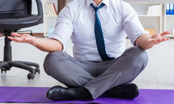 Man meditating in the office to cope with stress — Stock Photo, Image