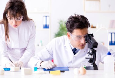 iki laboratuvar doktoru gıda ürünlerini test ediyor.