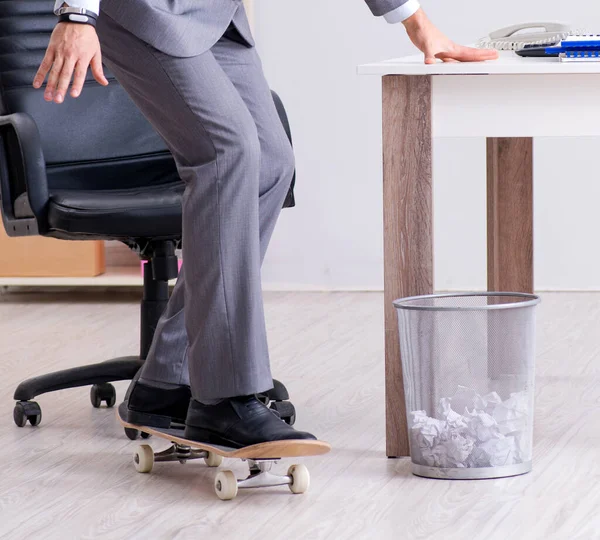 Junger Geschäftsmann fährt in der Pause Schlittschuh im Büro — Stockfoto