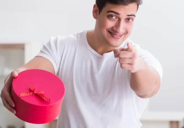 Ung man med presentpåse hemma förbereda suprise för hustru — Stockfoto