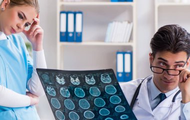 İki doktor teşhis için hastanın röntgen görüntülerini inceliyor.