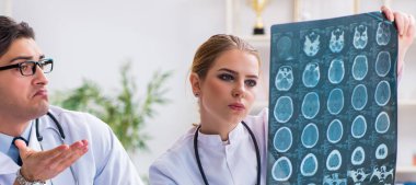 İki doktor teşhis için hastanın röntgen görüntülerini inceliyor.