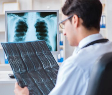 Doktor radyoloji uzmanı röntgen görüntülerine bakıyor.