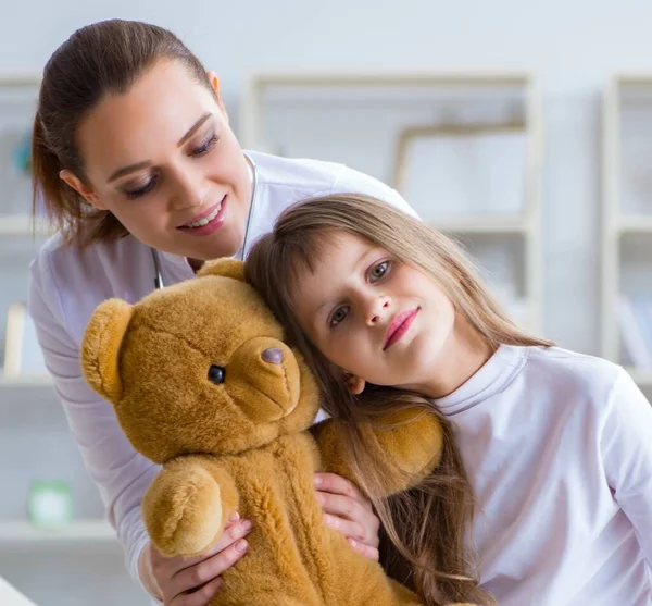 Ärztin untersucht kleines süßes Mädchen mit Spielzeugbär — Stockfoto
