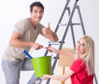 Ev tadilatı sırasında genç bir aile boya işi yapıyor.