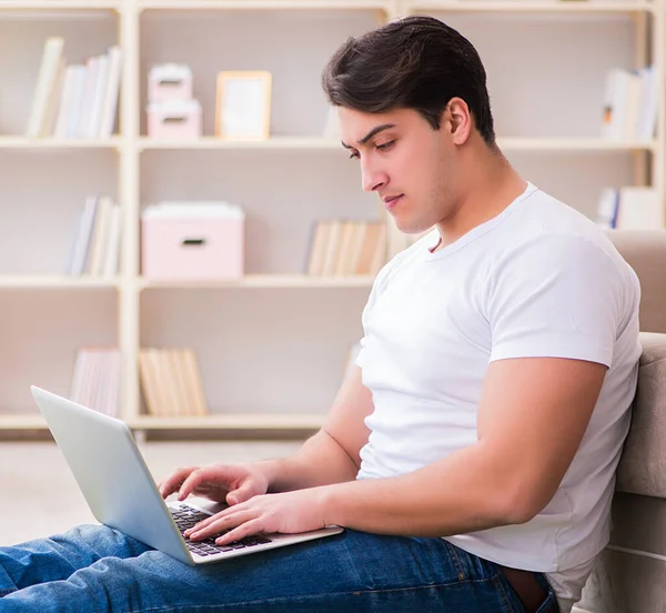 Man werkt op laptop thuis op tapijt vloer — Stockfoto