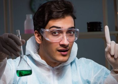 Gece geç saatlere kadar çalışan genç erkek kimyager.