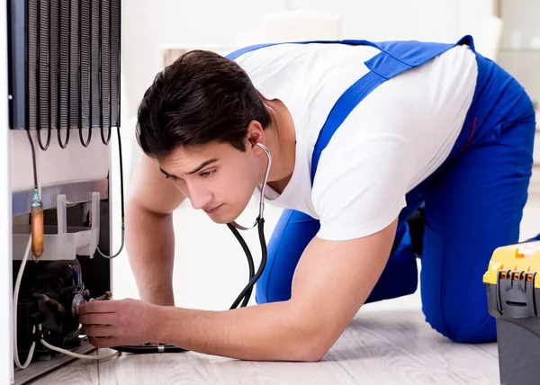 Repairman contractor repairing fridge in DIY concept