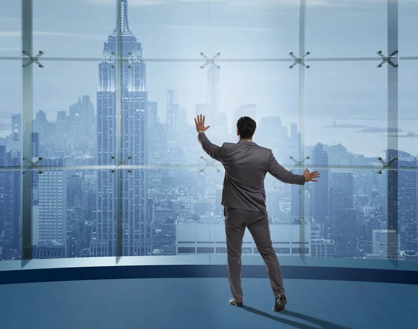 Businessman in front of office window thinking of new challenges — Stock Photo, Image