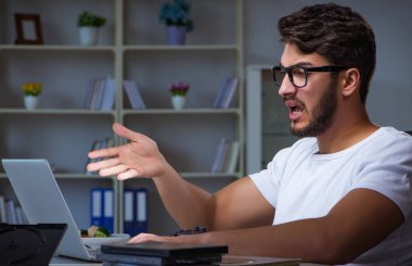 Genç adam fazla mesai yapmak için geç saatlere kadar ofiste kalıyor.