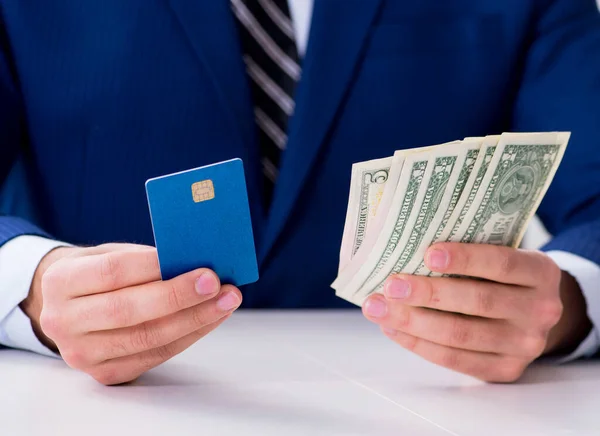 นักธุรกิจถือเงินดอลลาร์และบัตรเครดิต — ภาพถ่ายสต็อก