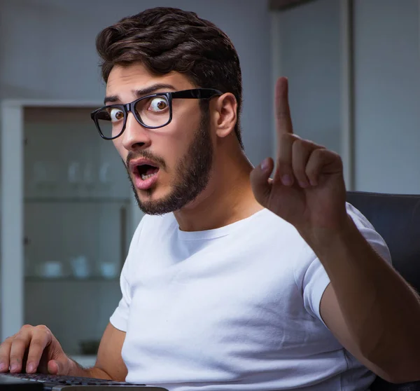 Genç adam fazla mesai yapmak için geç saatlere kadar ofiste kalıyor. — Stok fotoğraf