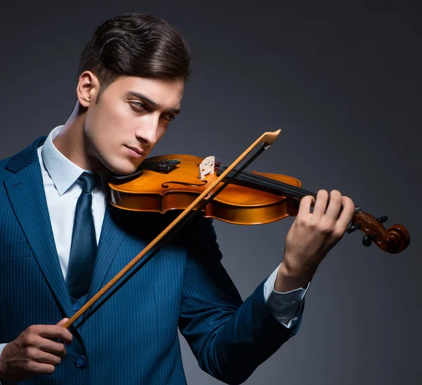 Jovem tocando violino no quarto escuro — Fotografia de Stock