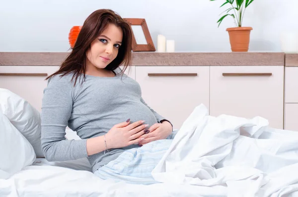 Junge schwangere Frau im Schlafzimmer — Stockfoto