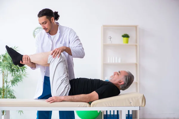 Viejo hombre herido visitando joven médico — Foto de Stock