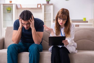 Genç bir erkek hasta kadın psikologla konuşuyor.