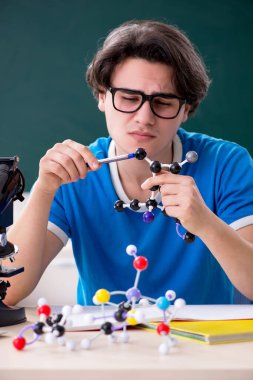 Sınıftaki genç erkek öğrenci.