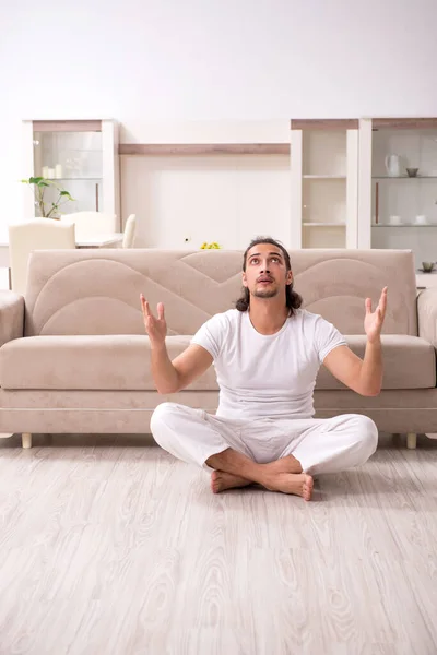 Jeune homme faisant des exercices physiques à la maison — Photo