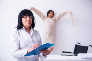 Yaşlı kadın psikiyatrist genç erkek hastayı ziyaret ediyor